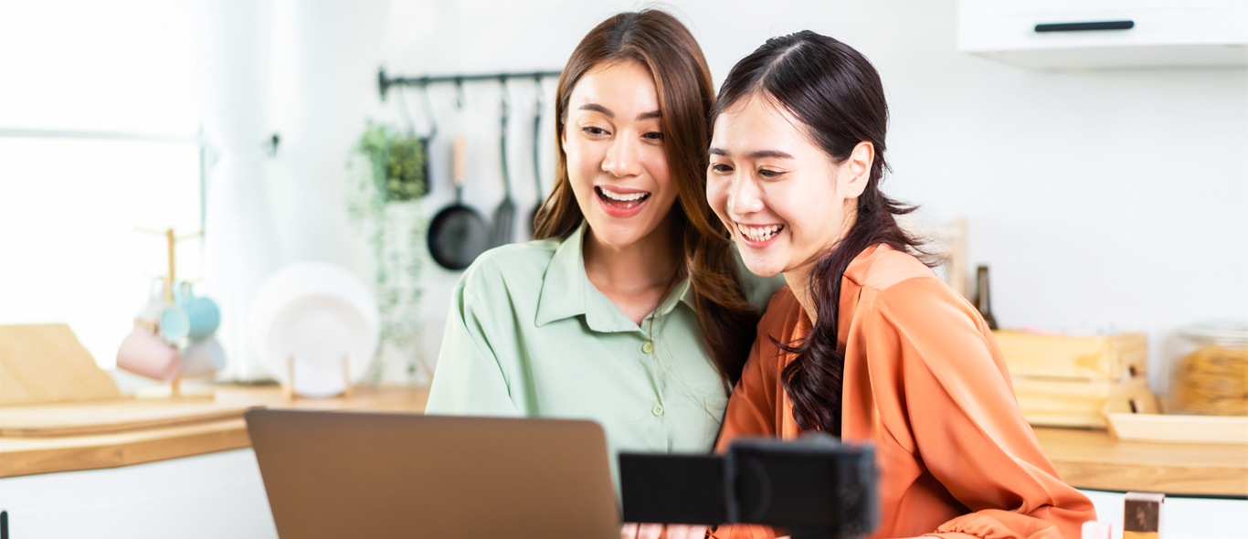 dua wanita sedang melihat laptop