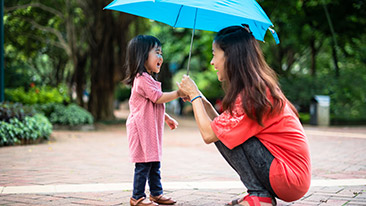 Ibu membawa payung bersama anaknya
