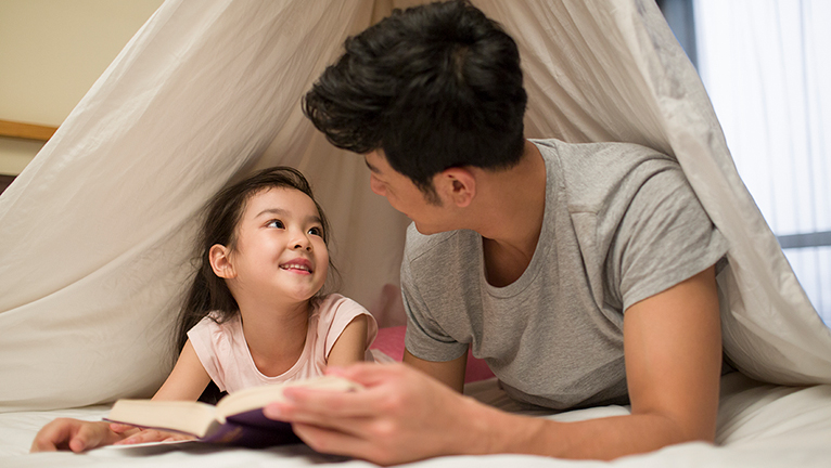 Ayah dan anak sedang membaca buku
