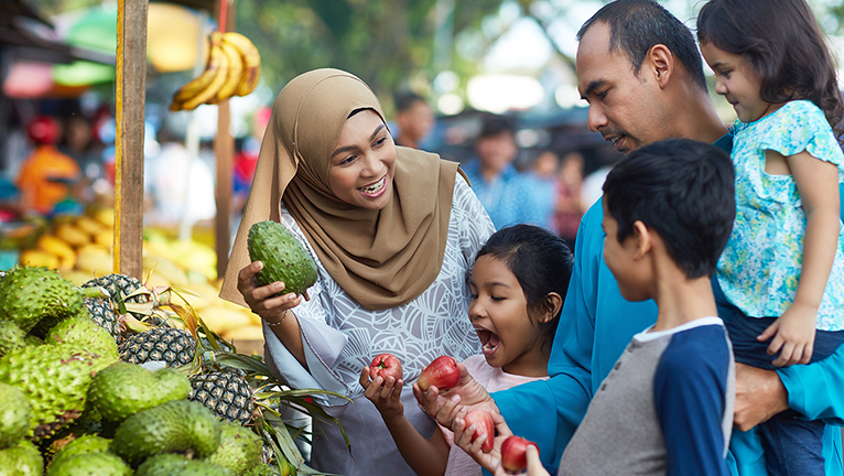 Keluarga sedang belanja buah di pasar