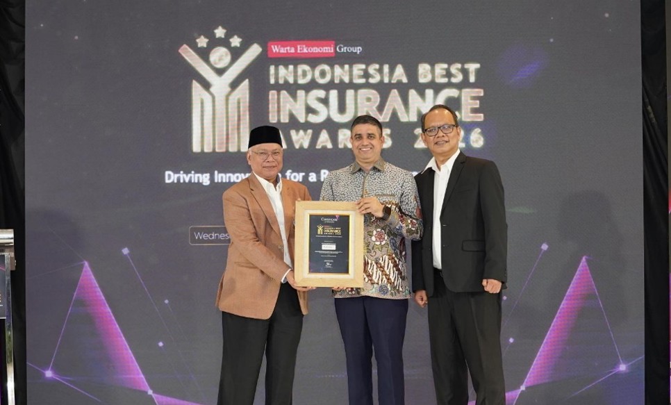 Three men stand on stage during the Indonesia Best Insurance Awards 2016 event. The central figure holds a framed award while the others pose beside him in formal attire. The backdrop displays the event title, Warta Ekonomi Group, and the phrase "Driving Innovation for a Better Future." Stage lighting and graphic elements create a professional award ceremony atmosphere.